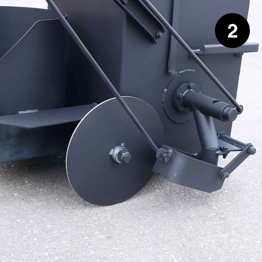 Close-up of a black kettle with a wheel on a light gray background