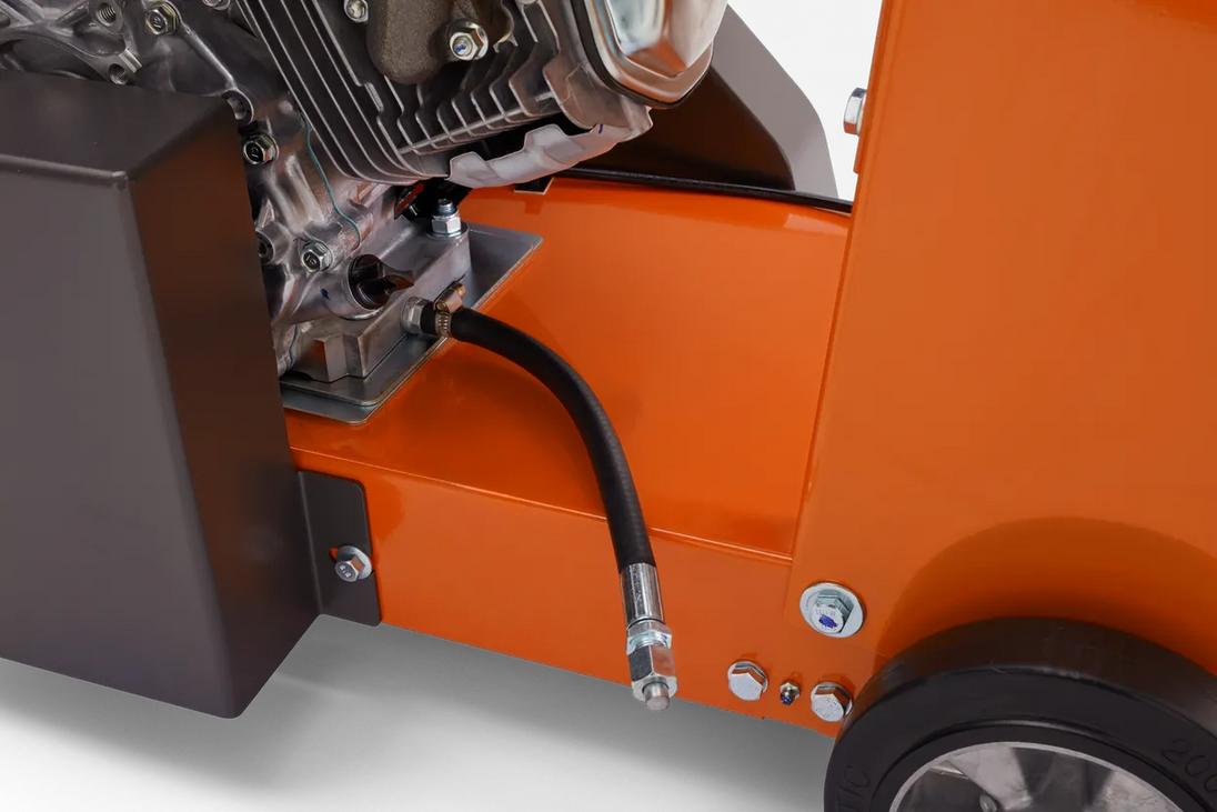Close-up of an orange piece of machinery with a black tube and metallic components.