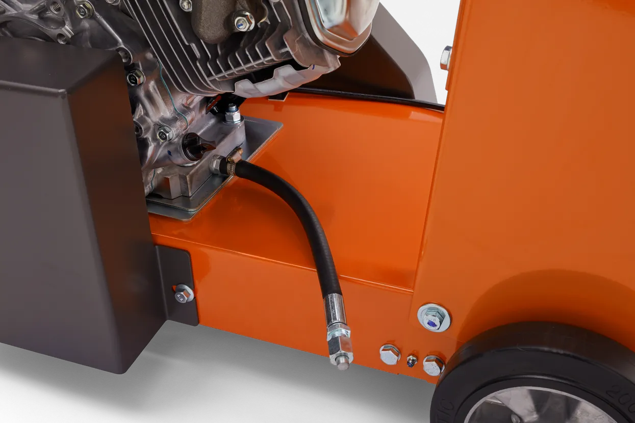 Close-up of an orange piece of machinery with a black tube and metallic components.