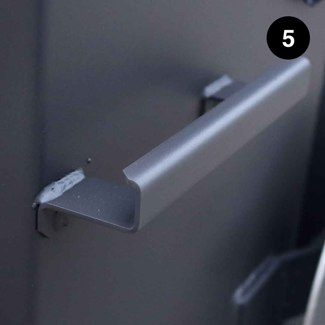 Metal bracket attached to kettle wall with a dark background