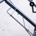Metal spring attached to a mechanical component on a light gray background
